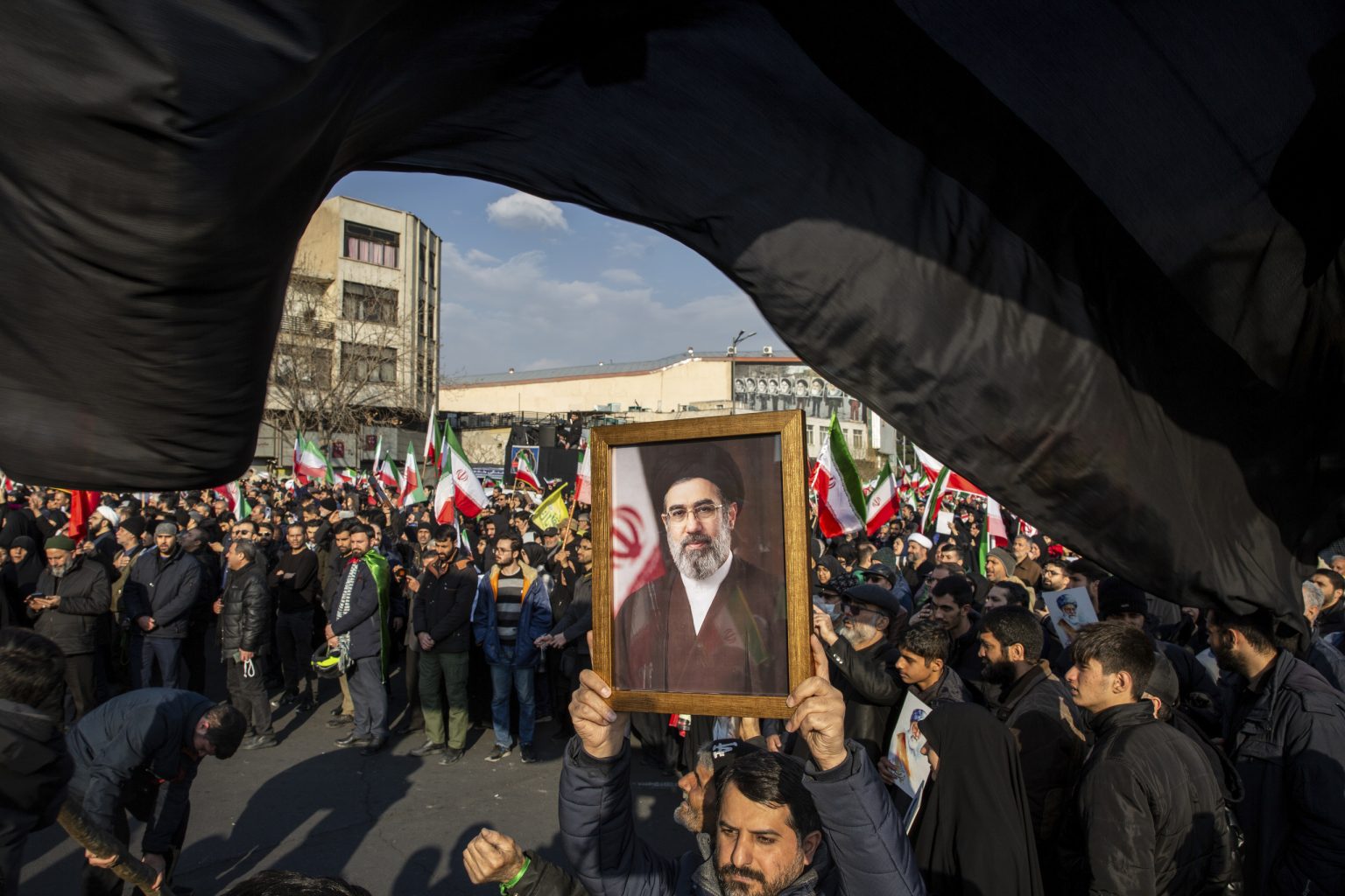 Dav s portrétom nového najvyššieho vodcu Iránu Modžtabu Chameneího oslavuje jeho zvolenie na námestí Enkeláb v Teheráne 9. marca 2026. Foto: Arash Khamooshi/New York Times