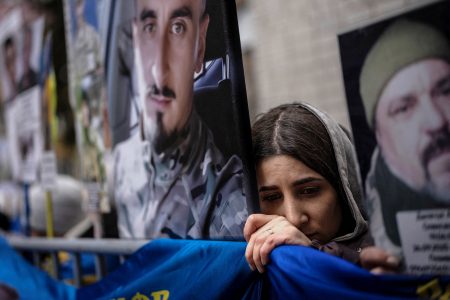 A woman waits for news about a missing loved one as Ukrainian soldiers return from captivity.