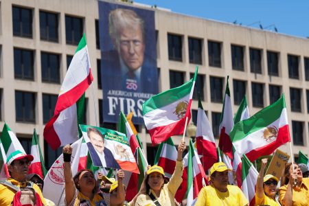Iranian Americans march in Washington with a banner of Donald Trump.
