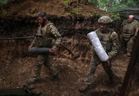 Ukrainian servicemen prepare to fire.