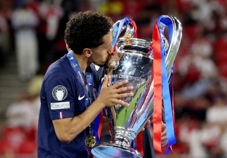 Paris St. Germain players celebrate with the trophy.