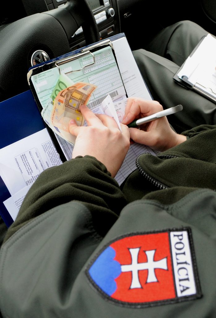 Policajt pri vypisovaní pokuty za porušenie pravidiel cestnej premávky. Foto: František Iván/TASR