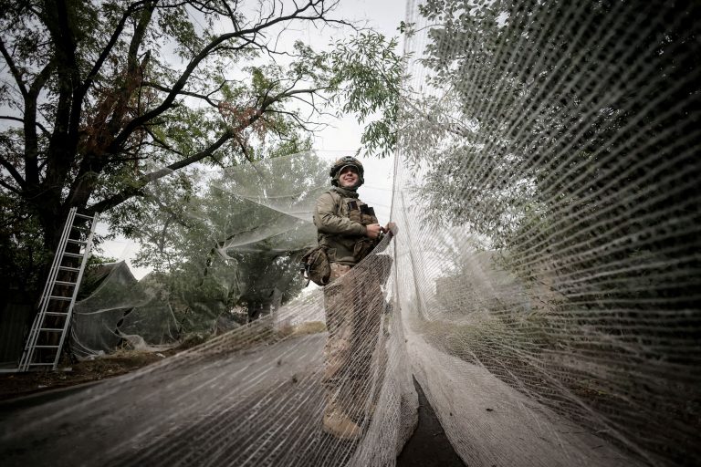 Serviceman installs anti-drone nets.