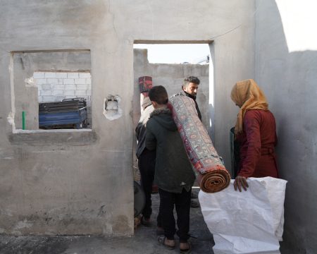 Syrians bring their belongings into a damaged house after returning to their village. Photo: Abdulvacit Hacisteyfi/Anadolu/Getty Images