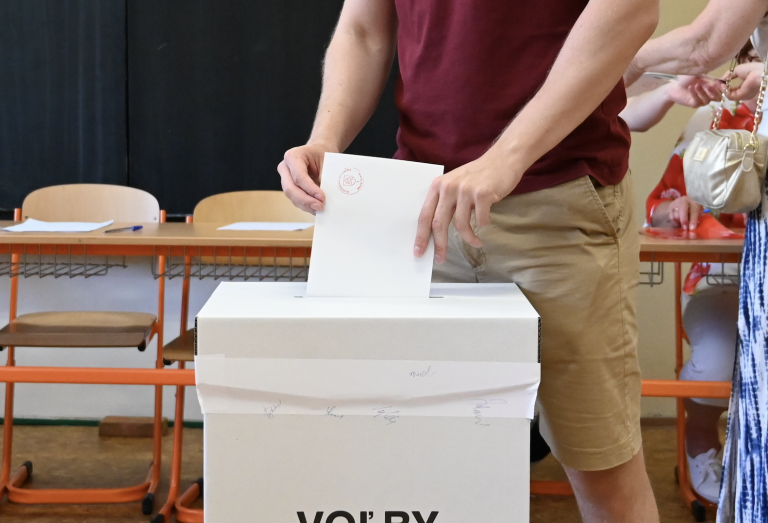 Muž vhadzujúci hlasovací lístok do volebnej urny.