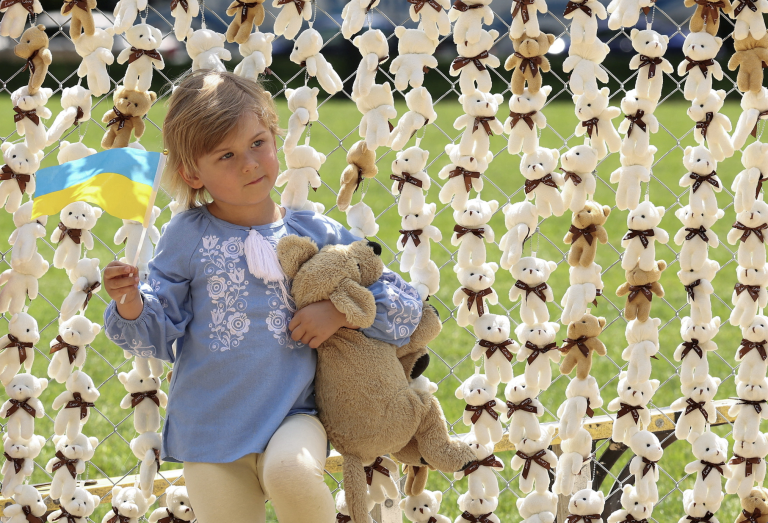 A girl holding a Ukrainian flag. Photo: Kevin Lamarque/Reuters
