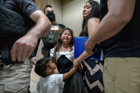 Migrants inside a US immigration office building.