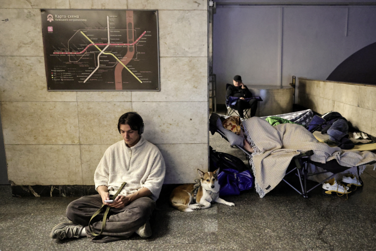 People shelter in a subway station during a drone attack.