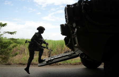 Soldier gets into a military vehicle.
