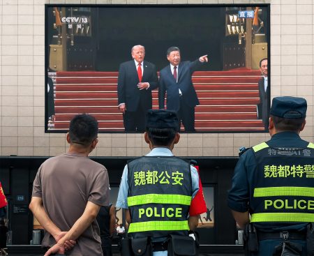 People outside a shopping mall watch Xi Jinping and Donald Trump on a screen. Photo: Cheng Xin/Getty Images