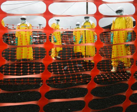 Workers in protective gear in an Ebola quarantine zone.