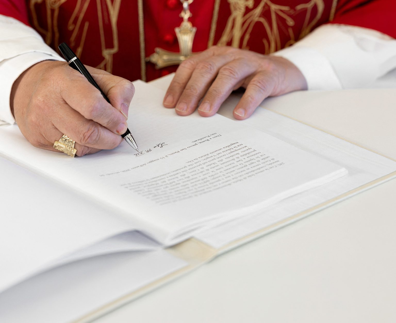 Pope Leo XIV signs a document at the Vatican.