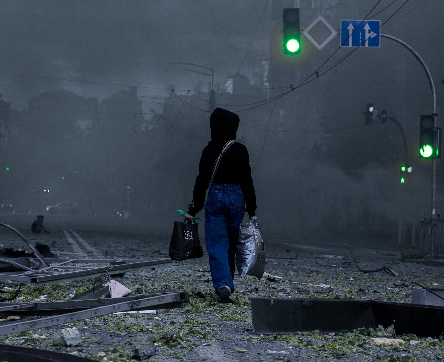 A woman walks on a debris-strewn street in Kyiv.