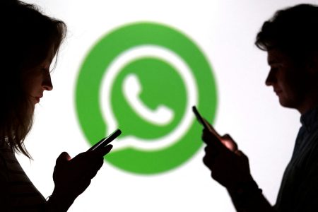 People in front of a WhatsApp logo.