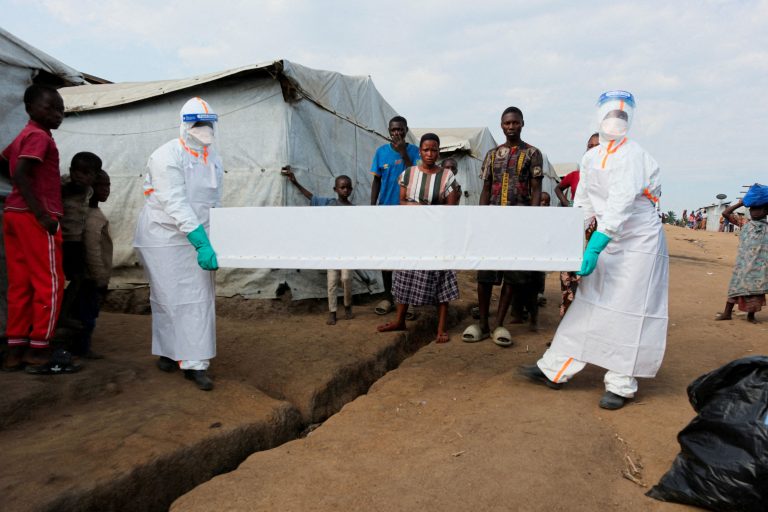 Health workers carry a coffin at Kigonze camp.
