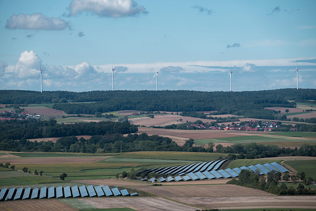 Solar panels and wind turbines on the horizon point to a growing problem in the energy transition: renewable power producers can end up cannibalizing one another. Photo: Daniel Vogl/picture alliance via Getty Images