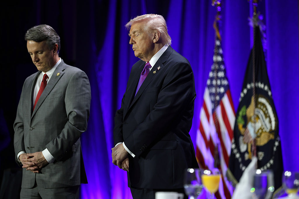 Donald Trump prays at the National Prayer Breakfast.