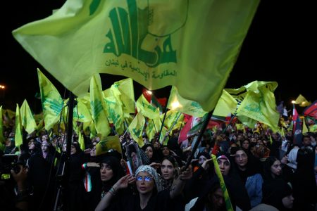 People hold Hezbollah flags.