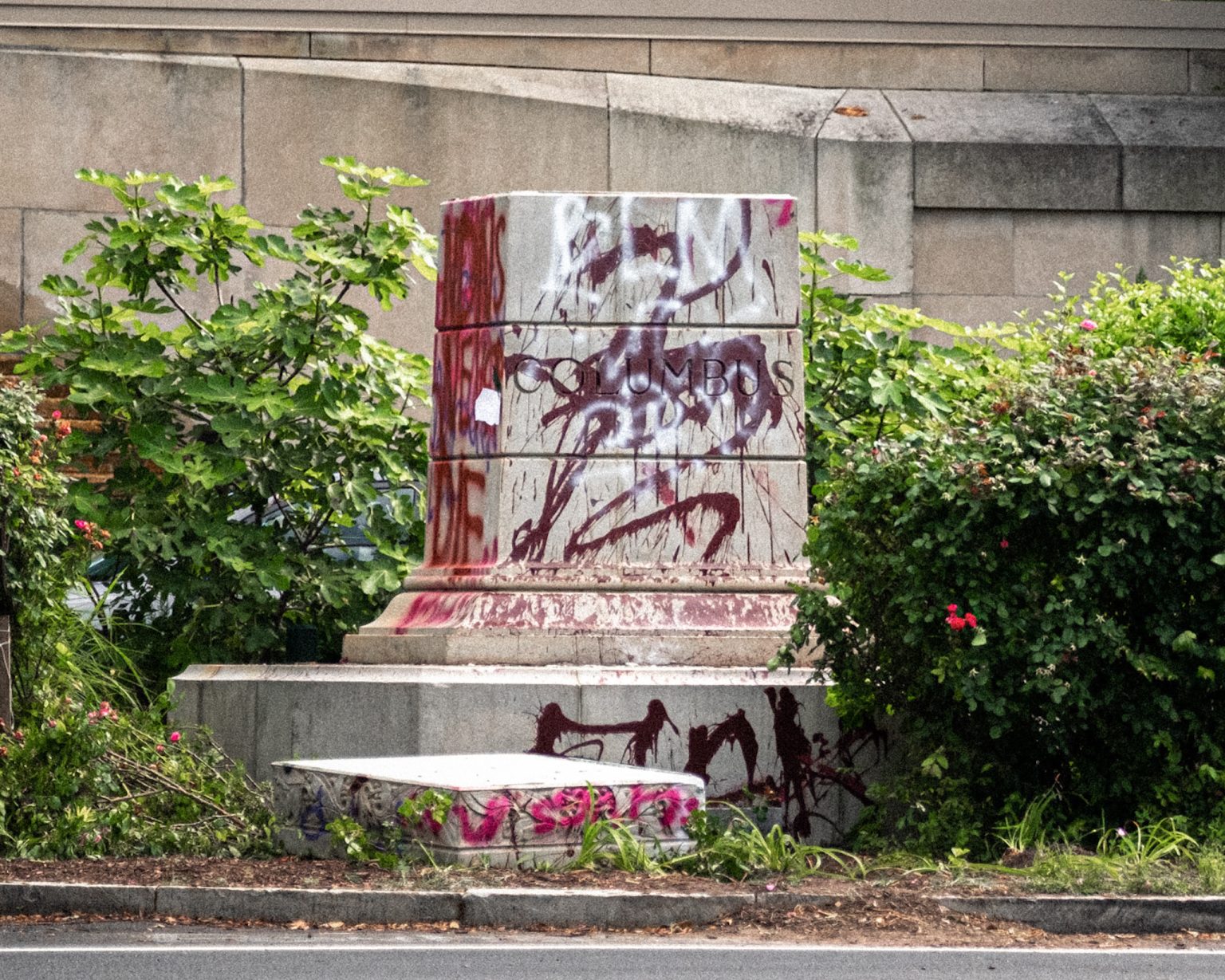 Plinth of Christopher Columbus statue defaced with paint.