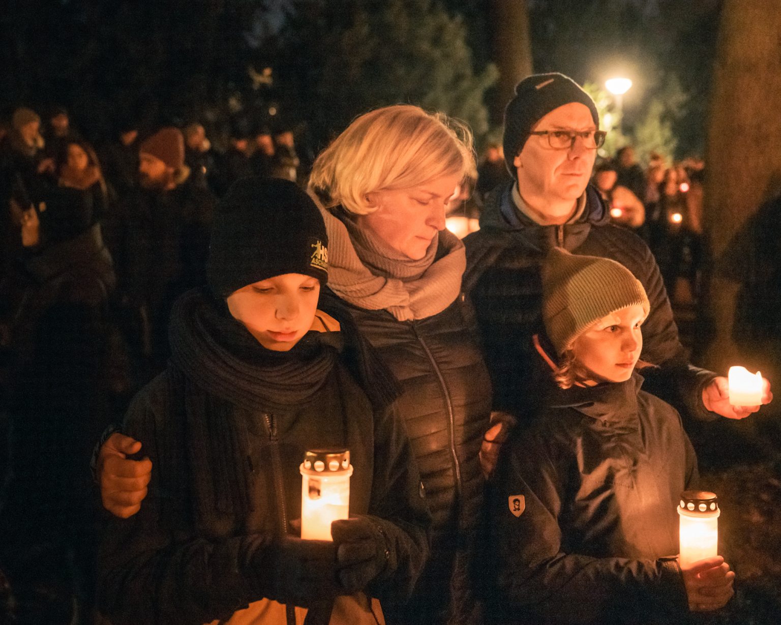People gather with candles for a silent vigil.