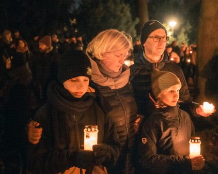 People gather with candles for a silent vigil.
