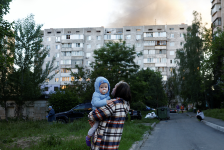 A resident carries a child in Kyiv after the attack.