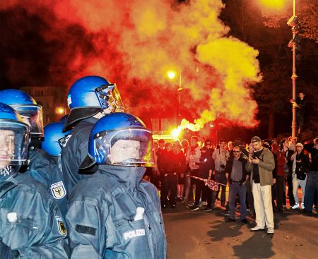 Police officers face protesters in Berlin.