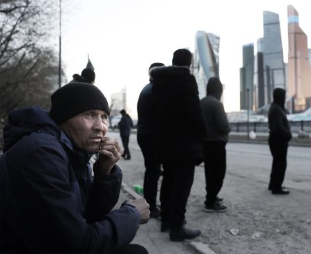 Central Asian migrants wait for a bus in Moscow.