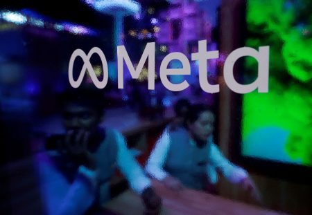 People behind a Meta Platforms logo at a conference in Mumbai.