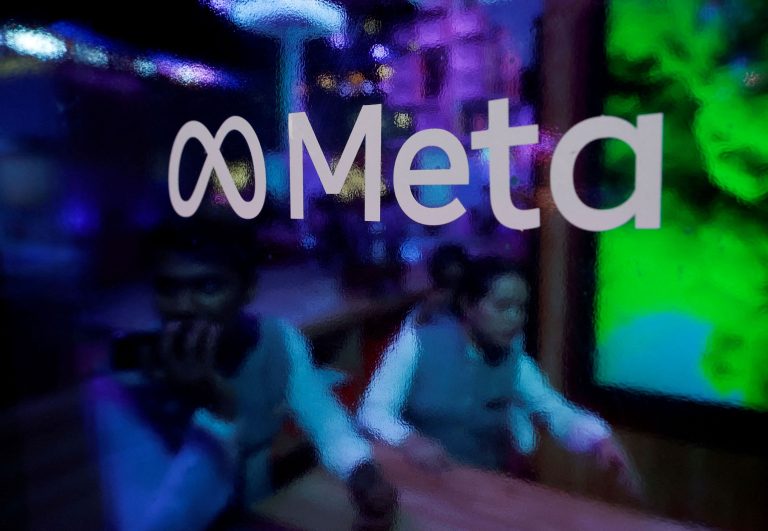 People behind a Meta Platforms logo at a conference in Mumbai.