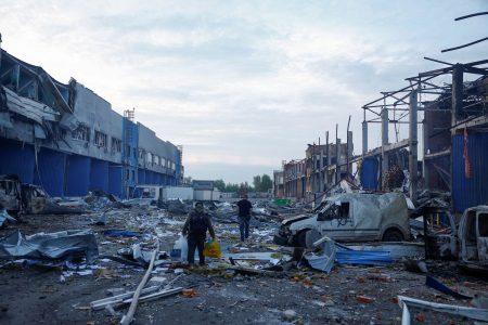 Workers inspect damage after a missile strike in Kyiv.