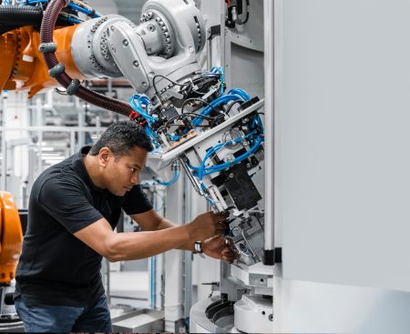 A worker attends to a robotic arm in Germany.