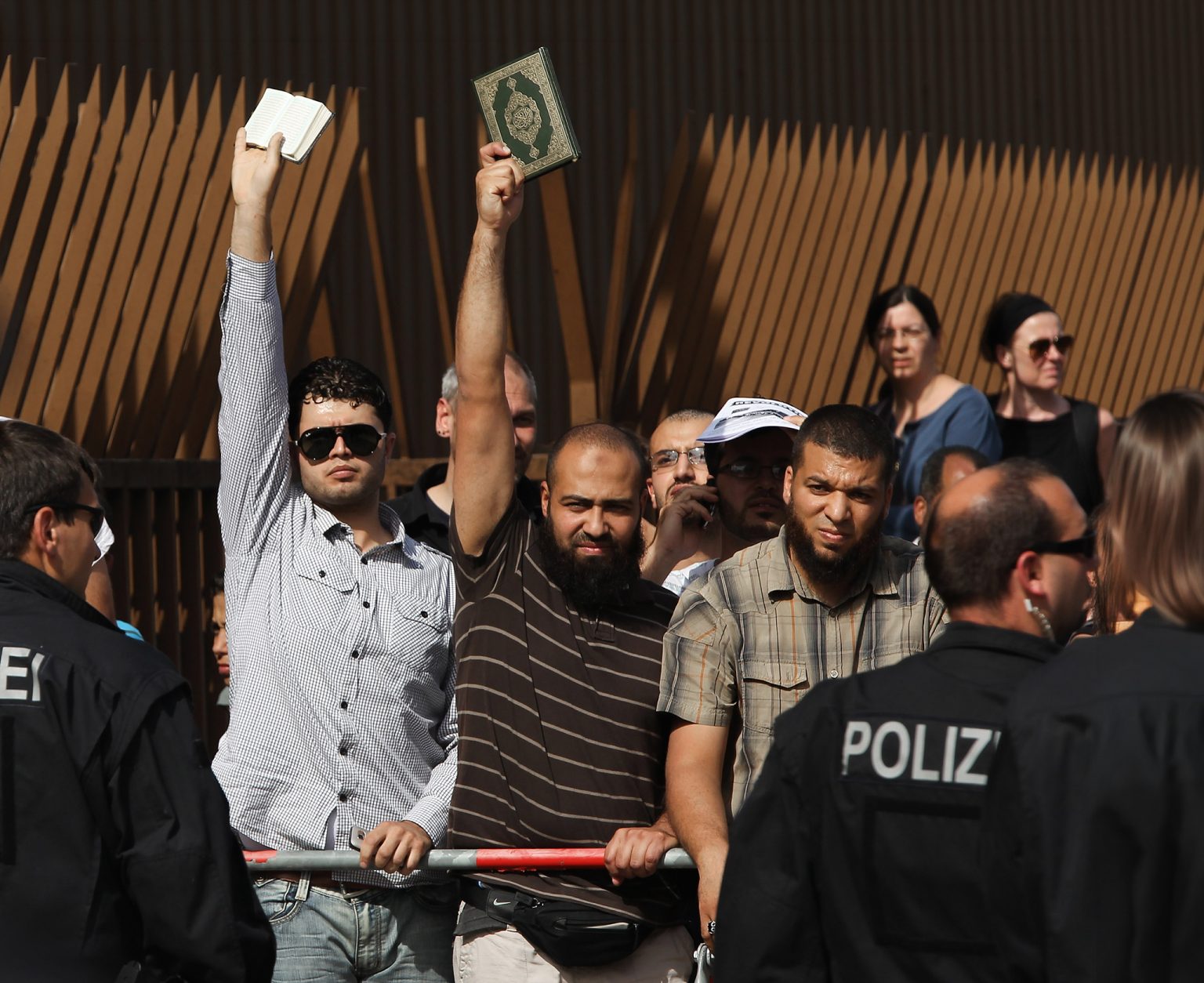 Muslim men hold copies of the Koran.
