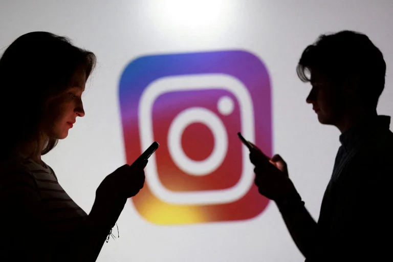 Tínedžeri pózujú pred logom Instagramu so smartfónmi.
