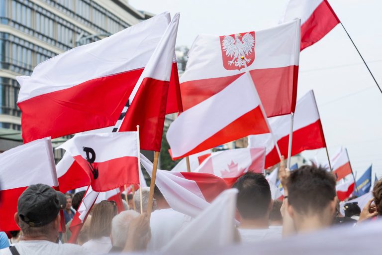 Ľudia s poľskými vlajkami.