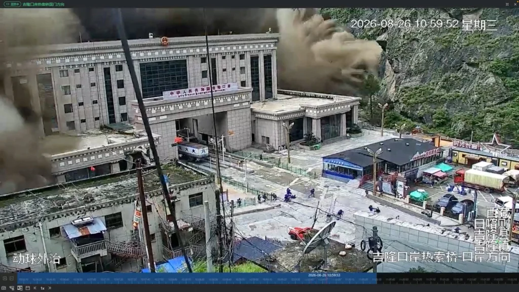 People running away as wall of mud and water destroys buildings in Gyirong. Photo: REUTERS/ Social media