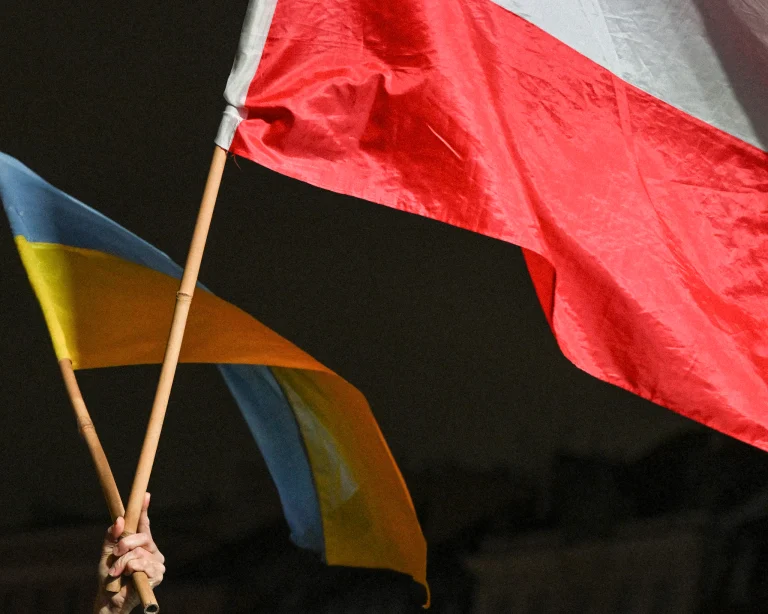 Protestujúci drží vlajky Ukrajiny a Poľska na zhromaždení.