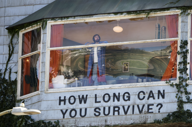 Man sitting in a billboard on Sunset Boulevard.