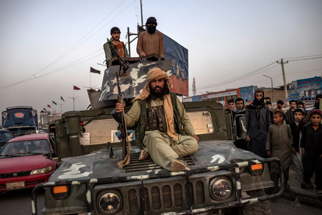 Bojovníci hnutia Taliban na opustenom vojenskom aute typu Humvee v afganskom Kábule 15. augusta 2021. Foto: Jim Huylebroek/New York Times