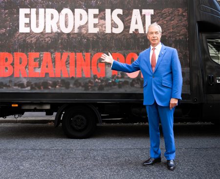 Nigel Farage with a digital poster outside the Horseguards Hotel.