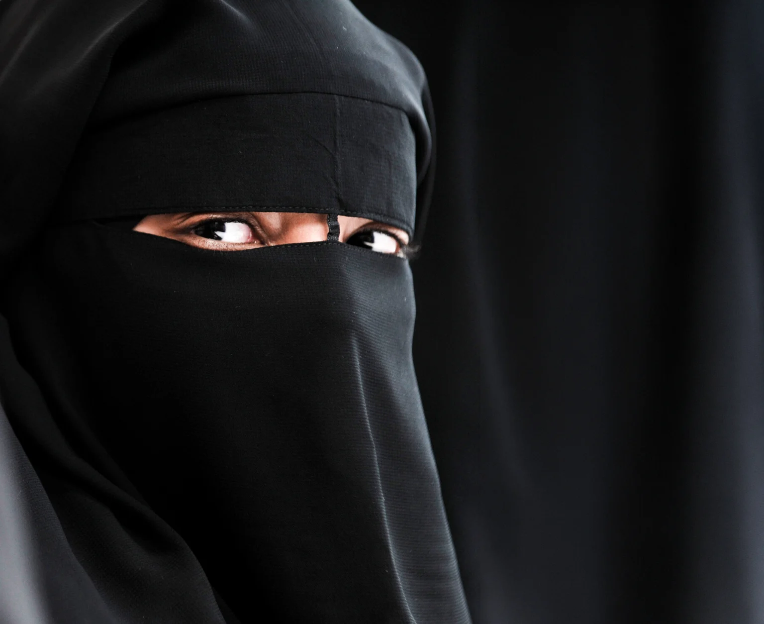 Woman with face covered by a veil.
