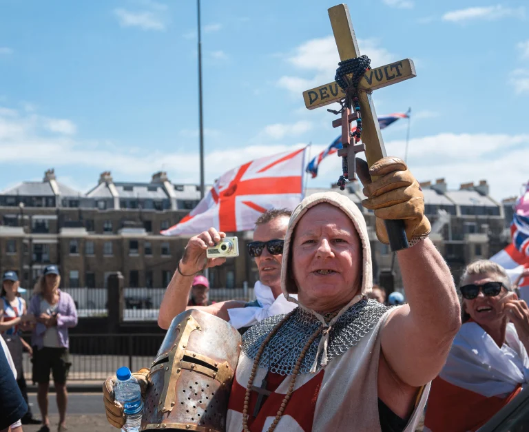 Protester dressed as a crusader holds a cross in Dover.