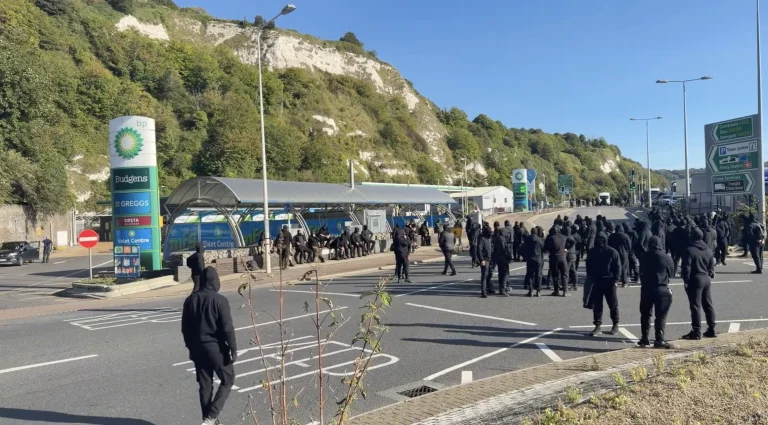 Protestujúci s kuklami sa zhromažďujú.